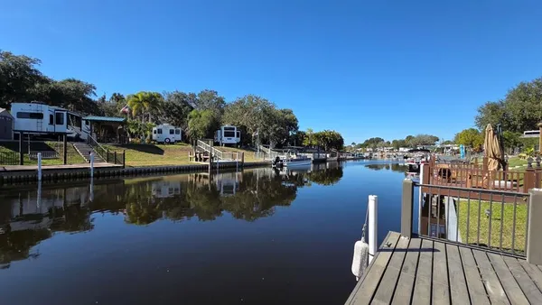 a view of a lake with boats and palm trees