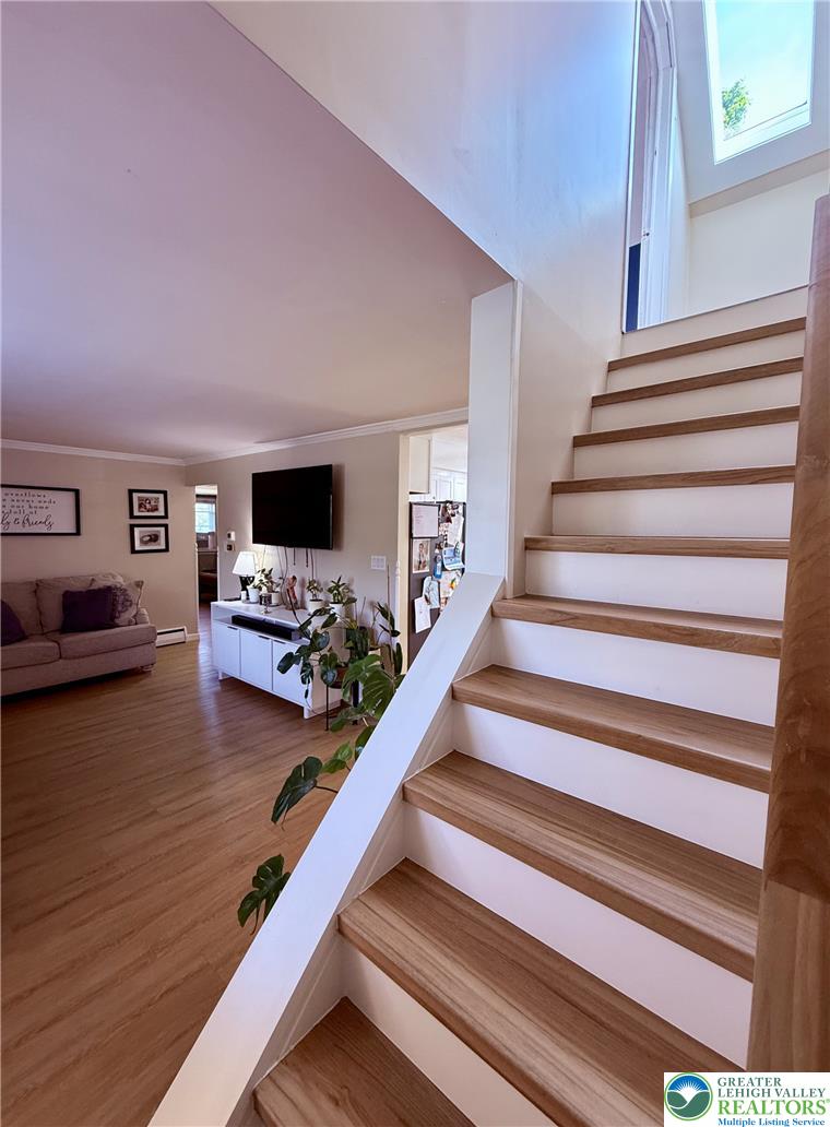 1275 Macada Road Bethlehem, PA 18017 - Photo 77 of 87 Natural wood treads and white risers create an inviting journey to the upper level, complementing the living area's warm flooring.