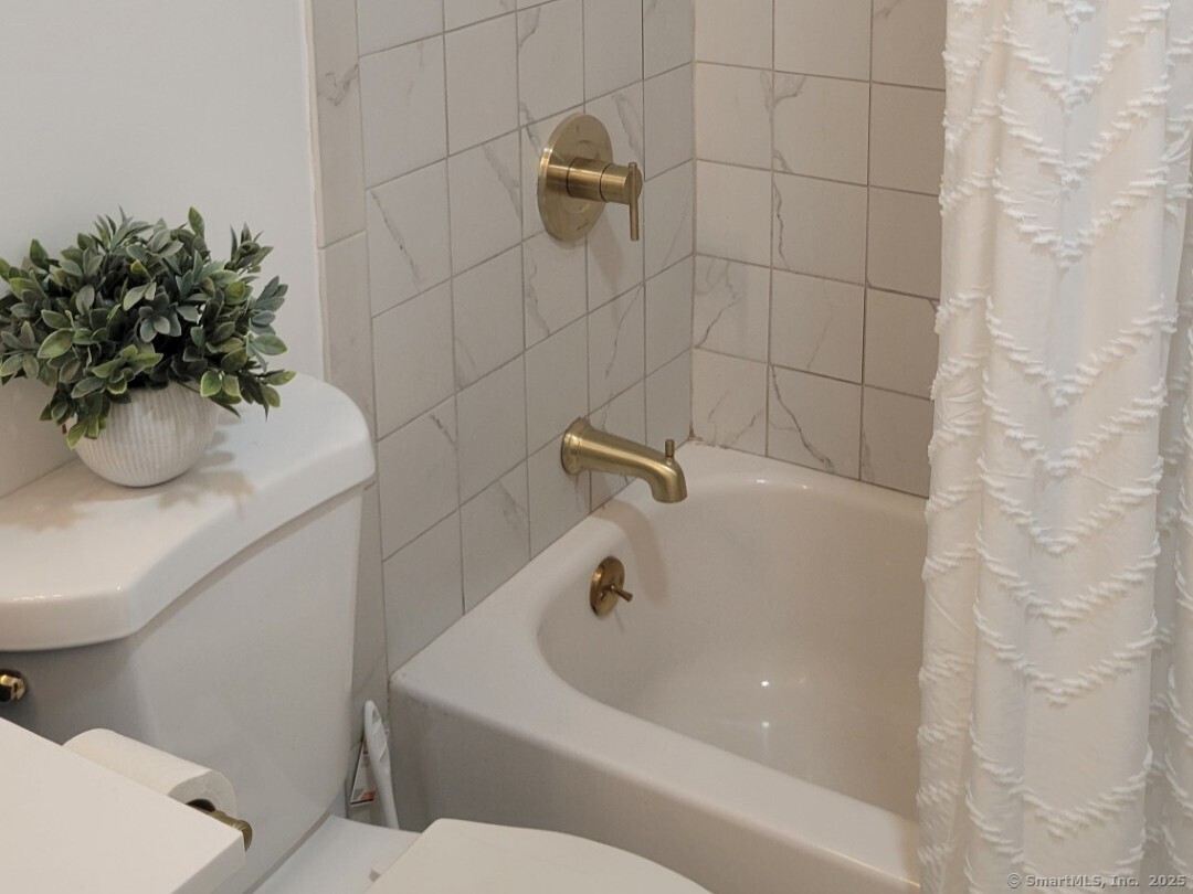 160 Fairfield Woods Road, Unit 43 Fairfield, CT 06825 - Photo 16 of 25 a bathroom with a white bath tub and a potted plant