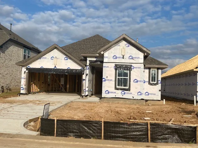 a view of a house with large windows and a wooden fence