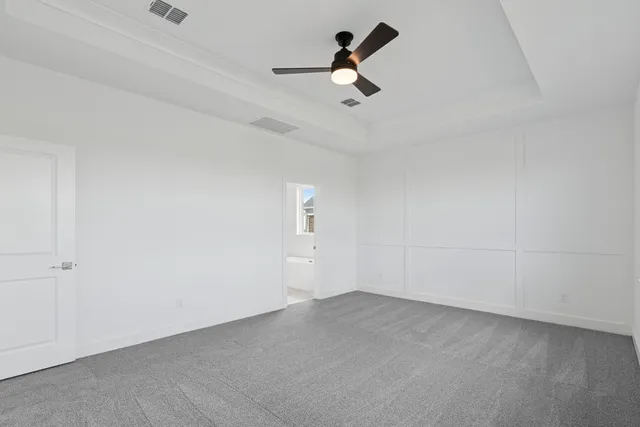 an empty room with a ceiling fan and window