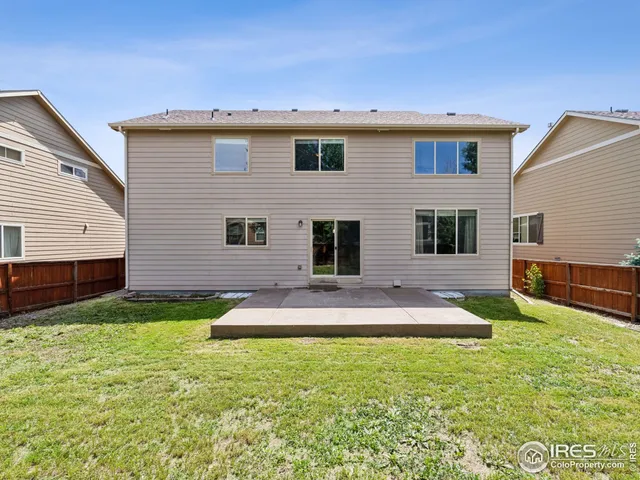 a front view of house with yard and trees in the background