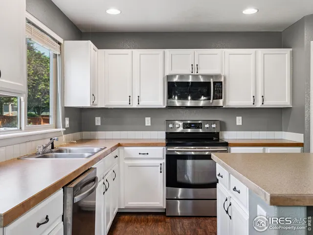 a kitchen with cabinets appliances a sink and a counter top space