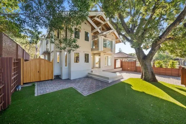a view of a house with a big yard and a large tree