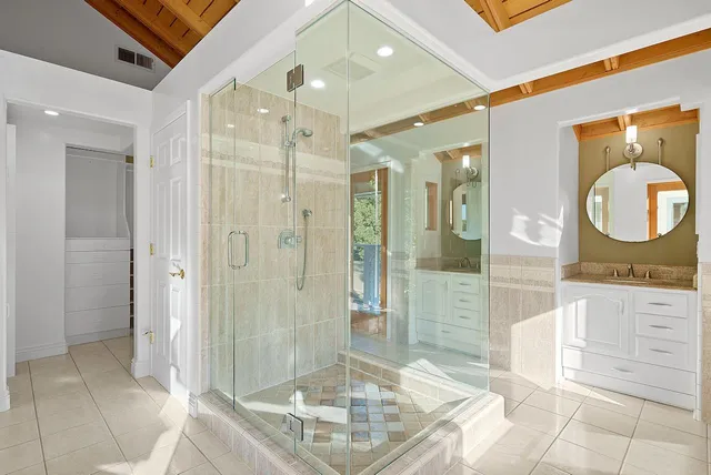 a bathroom with a shower a mirror and a sink