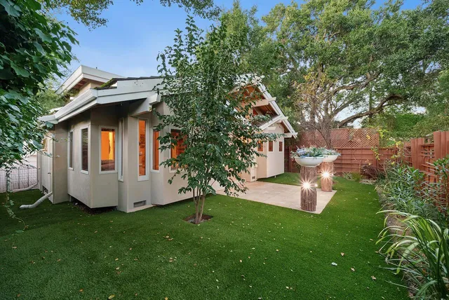 an aerial view of residential house with outdoor space and trees all around