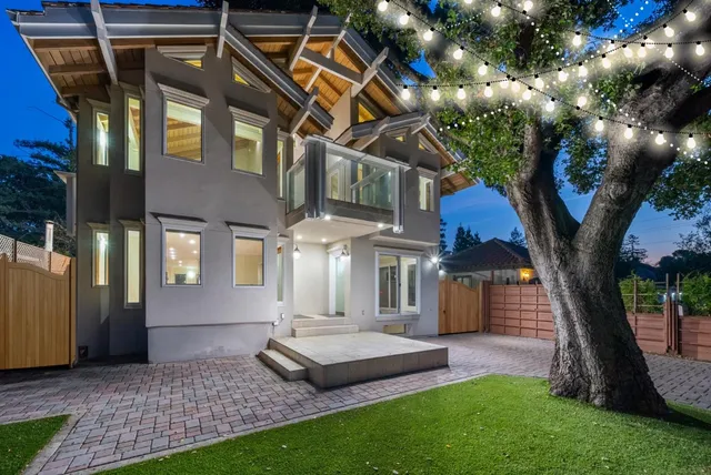 a front view of a house with a garden and trees