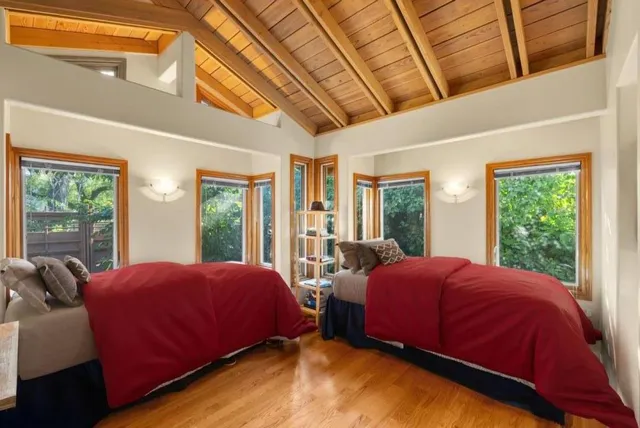 a bedroom with two beds and a large window