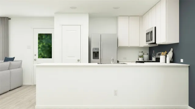 a kitchen with stainless steel appliances granite countertop a sink a stove and a refrigerator