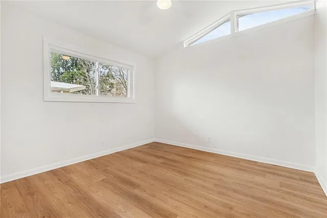 an empty room with wooden floor and window