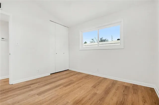an empty room with cabinet and wooden floor