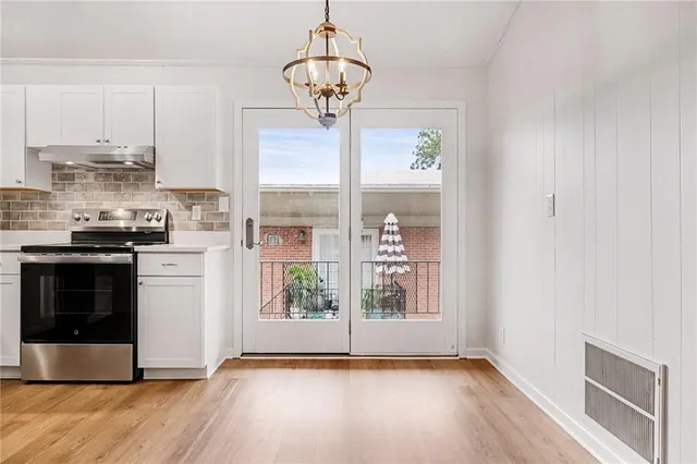 a kitchen with stainless steel appliances granite countertop a stove a microwave and a hard wood floor