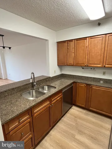 a kitchen with stainless steel appliances granite countertop a refrigerator a microwave a sink and white cabinets