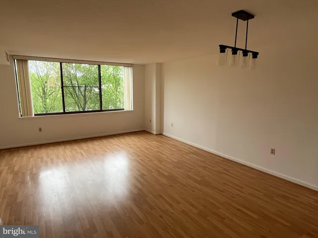 a view of empty room with wooden floor and fireplace