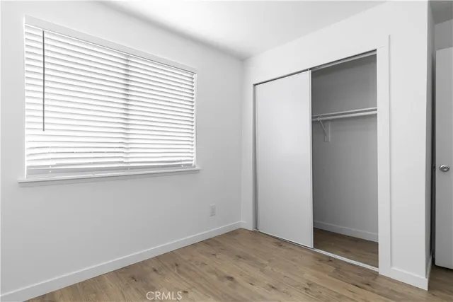 an empty room with wooden floor and a window