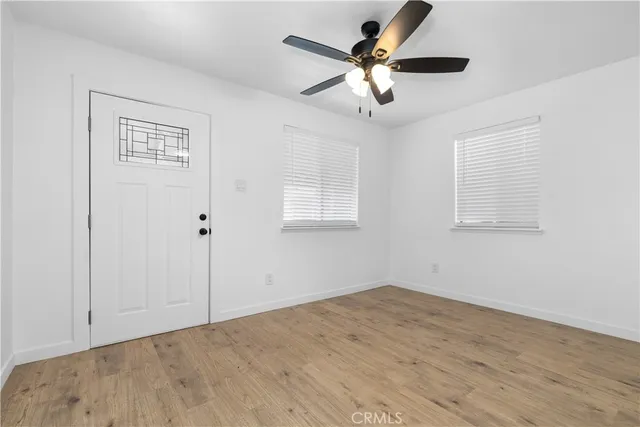 a view of a big room with wooden floor and windows