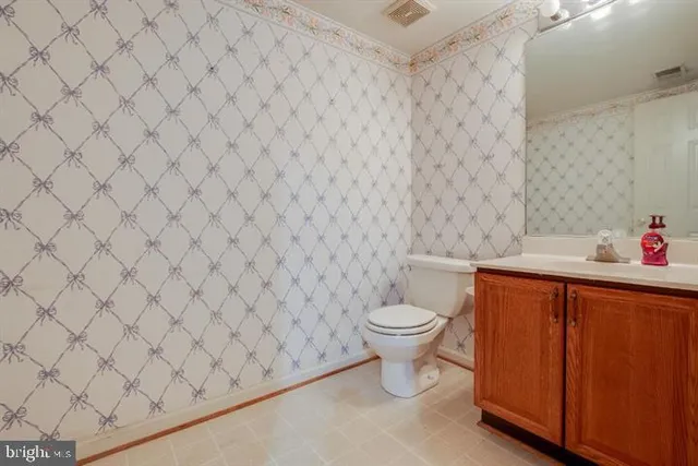 a white toilet sitting next to a white wall