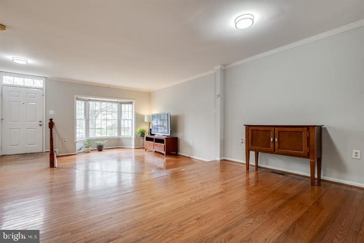 21186 Winding Brook Square Ashburn, VA 20147 - Photo 4 of 42 a view of an empty room with wooden floor and a window