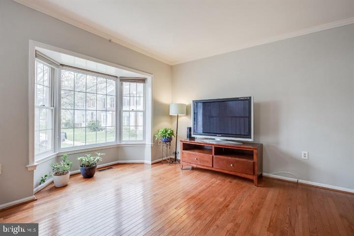 21186 Winding Brook Square Ashburn, VA 20147 - Photo 7 of 42 a living room with furniture a wooden floor and a window
