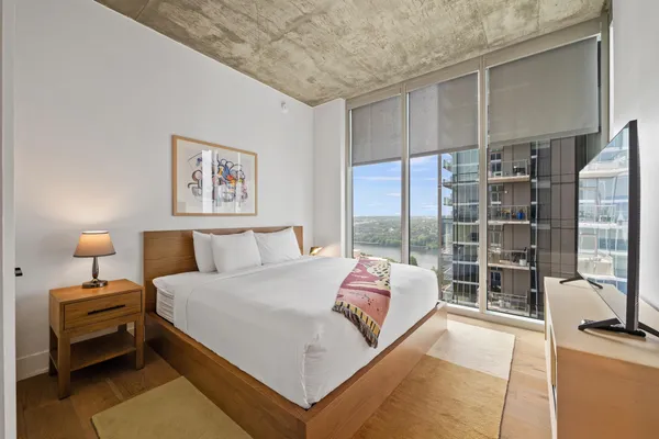 a bedroom with a bed and a large window