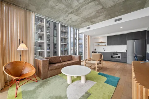 a living room with furniture a table and a large window