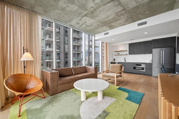 a living room with furniture a table and a large window