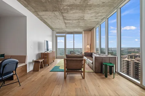 a living room with furniture a wooden floor and next to a window