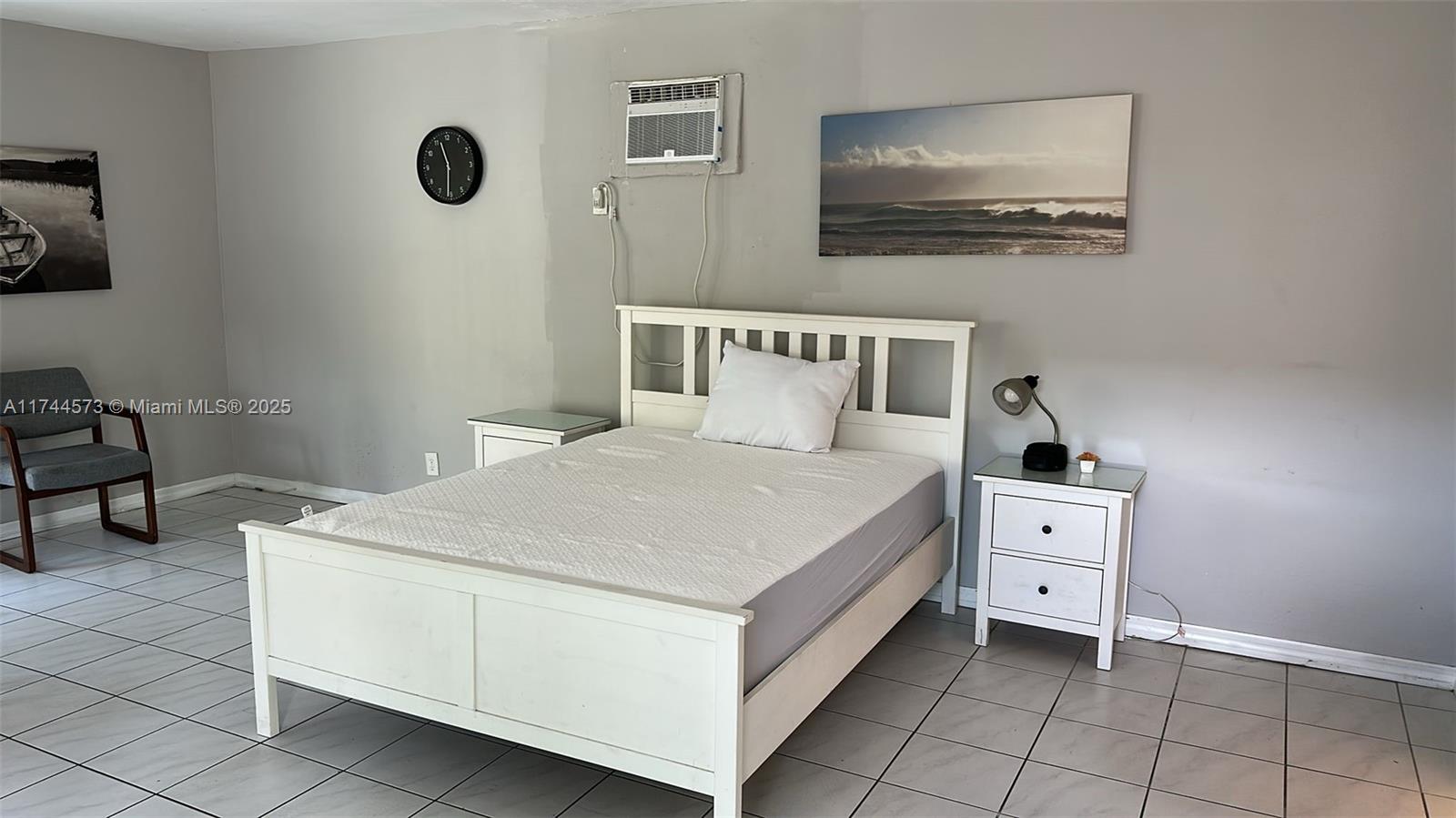 90 Isle Of Venice Drive, Unit 1 Fort Lauderdale, FL 33301 - Photo 2 of 7 a bedroom with a bed and a chandelier