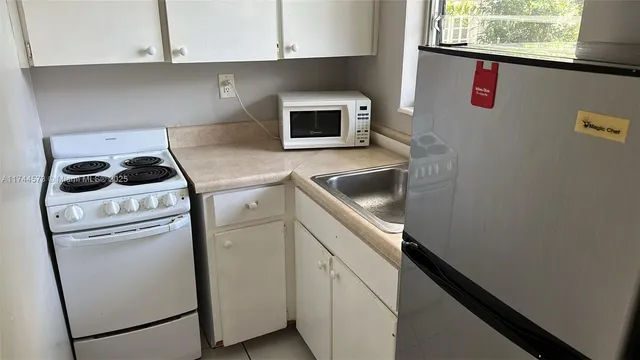 a kitchen with a stove and white cabinets