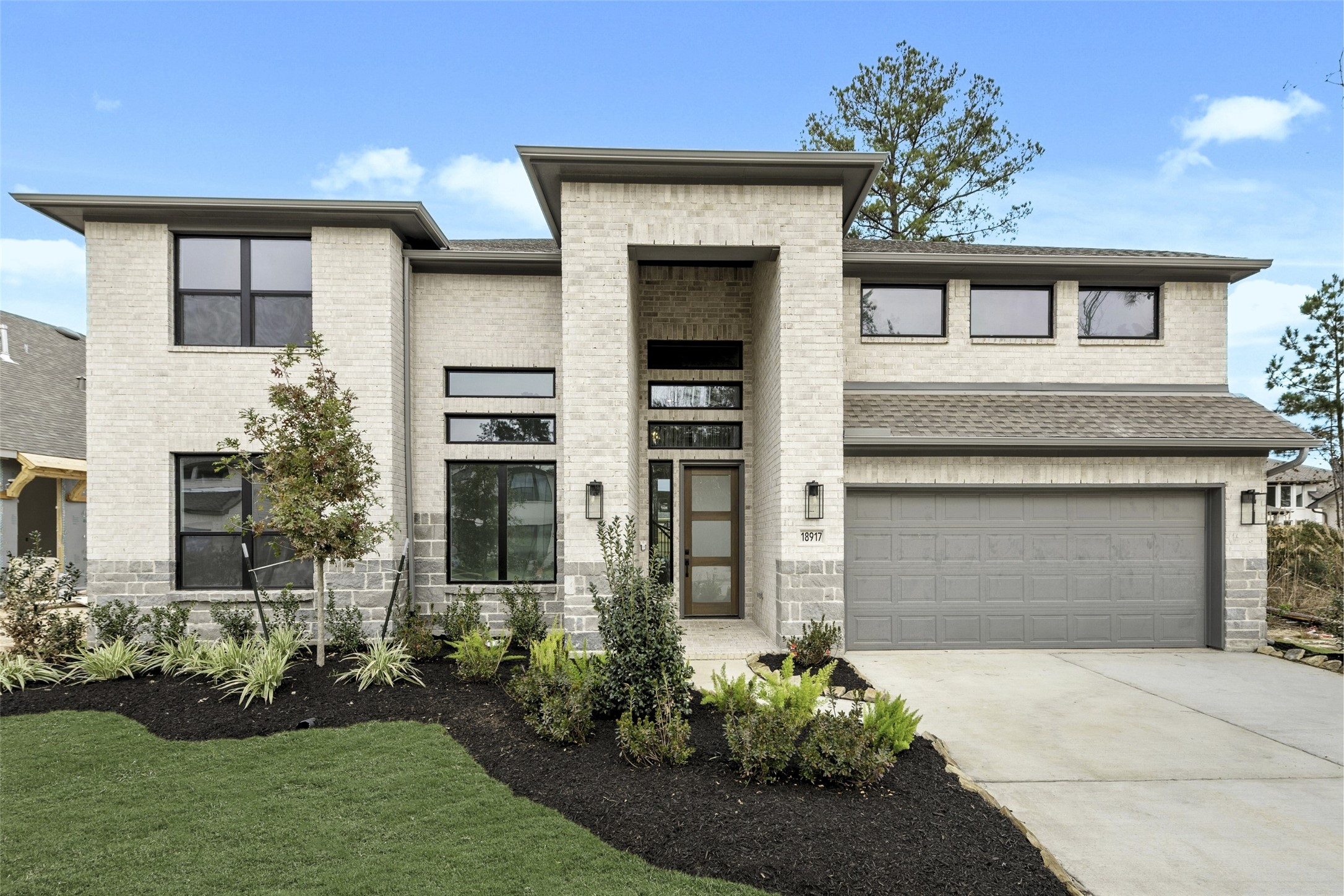 18917 Moonriver Street Conroe, TX 77302 - Photo 1 of 28 a front view of a house with a garden