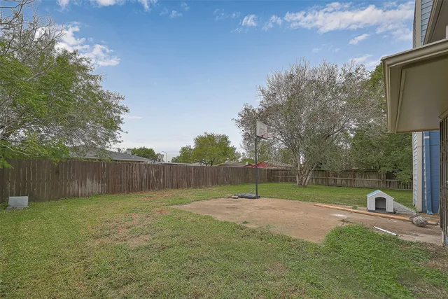a view of a basketball area in the backyard