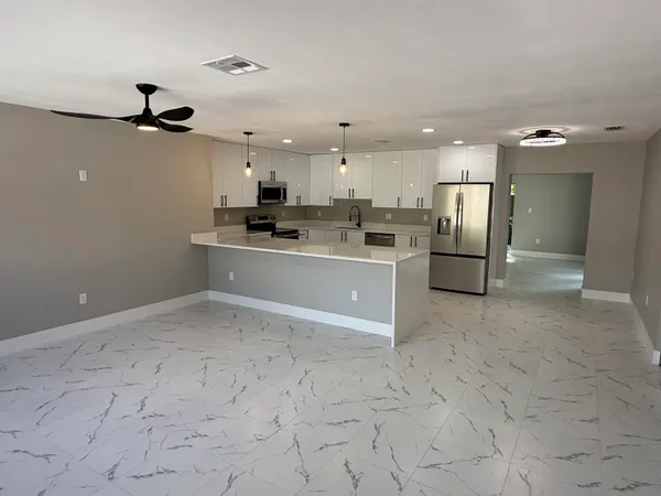 a view of a kitchen with a sink and stainless steel appliances