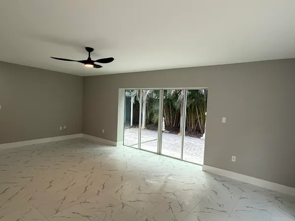a view of a livingroom with a ceiling fan and window