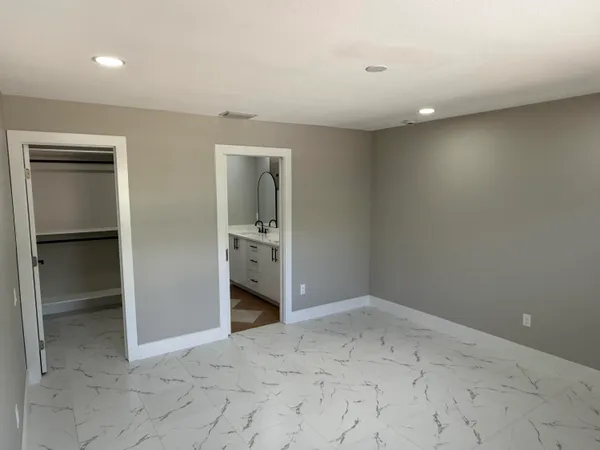 an empty room with closet and mirror