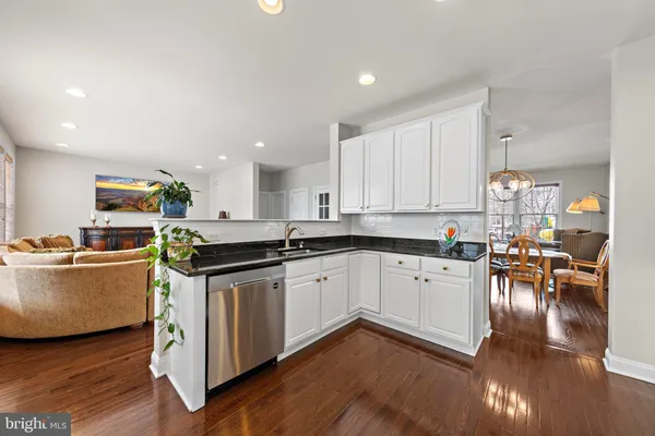 a kitchen with stainless steel appliances granite countertop a stove top oven a sink a counter space and cabinets