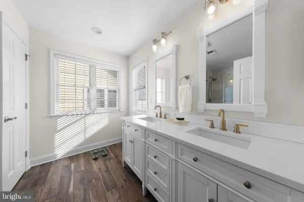a bathroom with a double vanity sink a mirror and a bathtub
