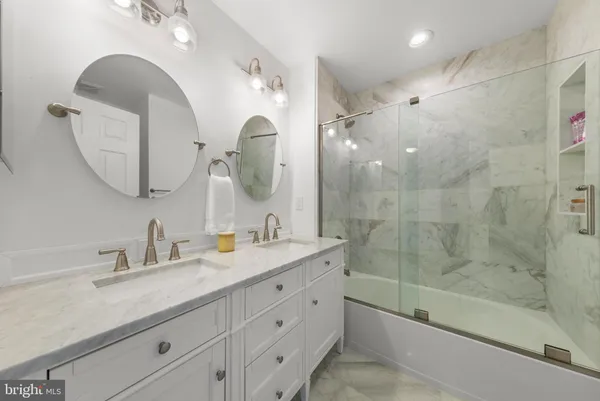 a bathroom with a double vanity sink mirror double and shower