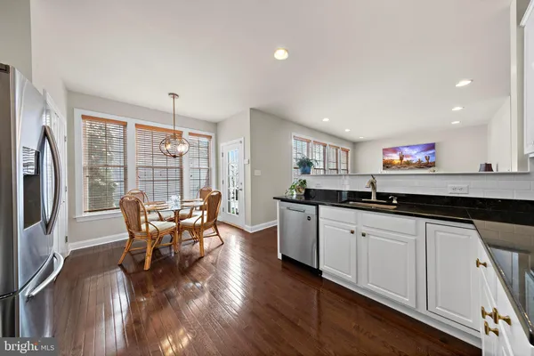 a kitchen with stainless steel appliances granite countertop a sink and dining table chair