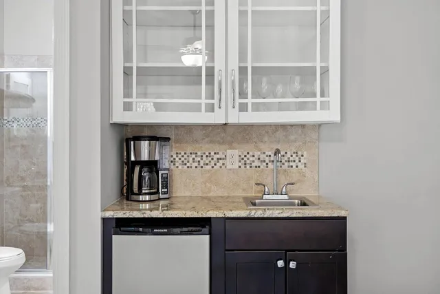 a bathroom with a granite countertop sink toilet a mirror and shower