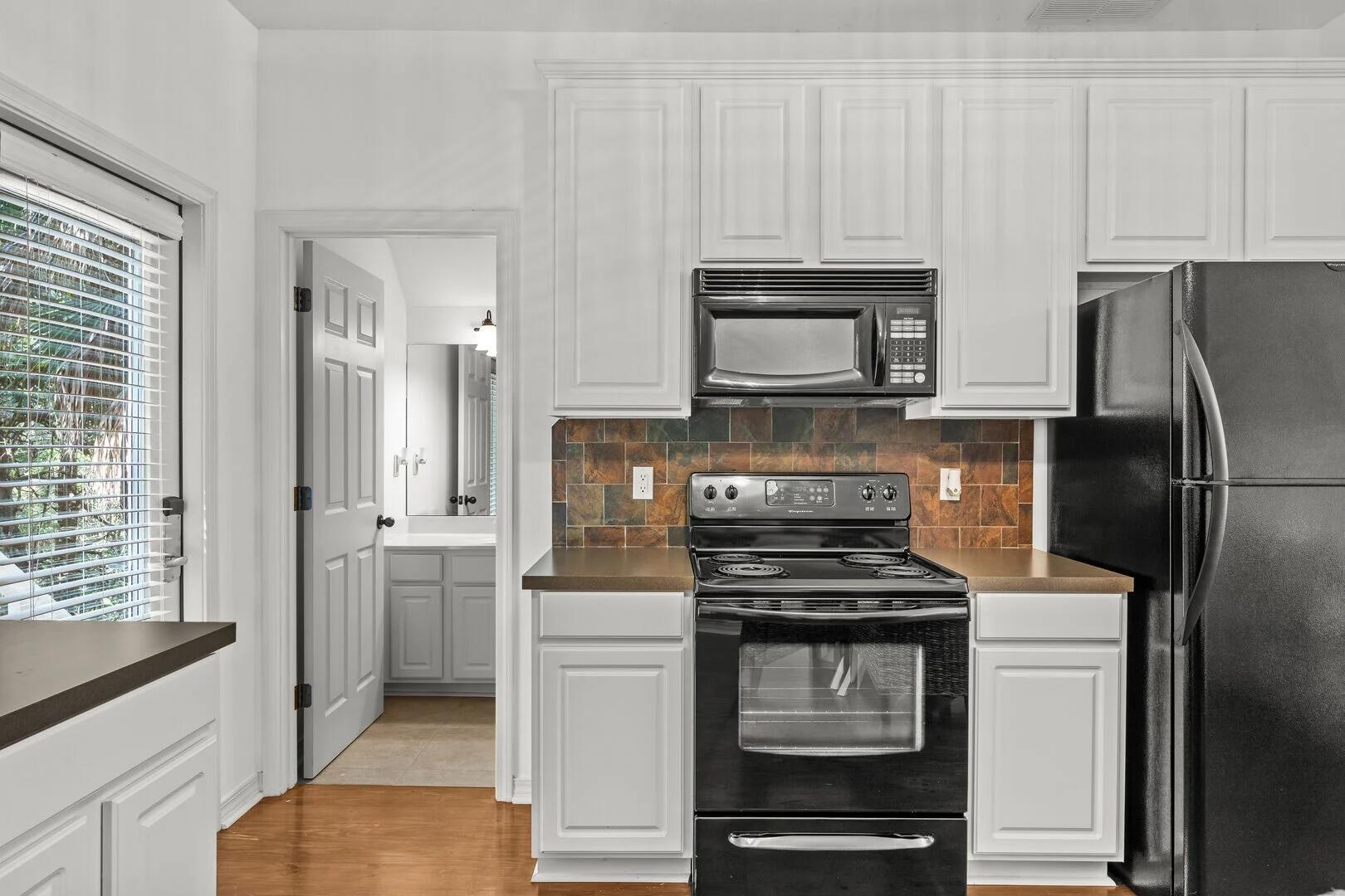 2059 Mack Bayou Road Santa Rosa Beach, FL 32459 - Photo 46 of 51 a kitchen with cabinets stainless steel appliances and a window