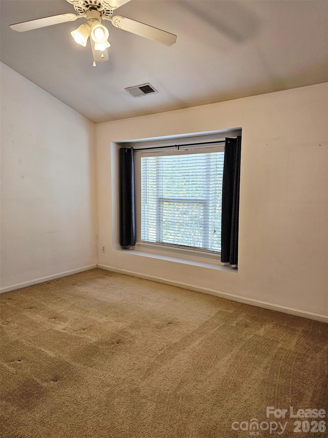 10609 Fuller Ridge Circle Charlotte, NC 28270 - Photo 14 of 29 an empty room with a chandelier fan and windows