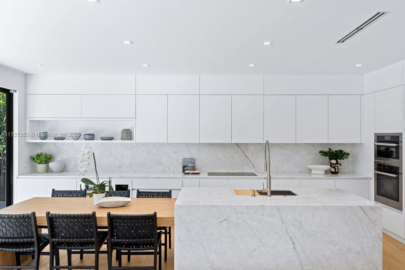 10 Pinta Road Miami, FL 33133 - Photo 11 of 28 a kitchen with granite countertop sink table and chairs