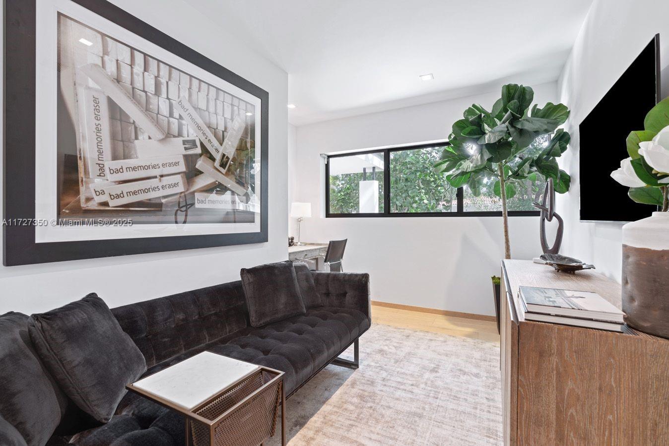 10 Pinta Road Miami, FL 33133 - Photo 16 of 28 a living room with furniture a large window with a flat screen tv and a potted plant