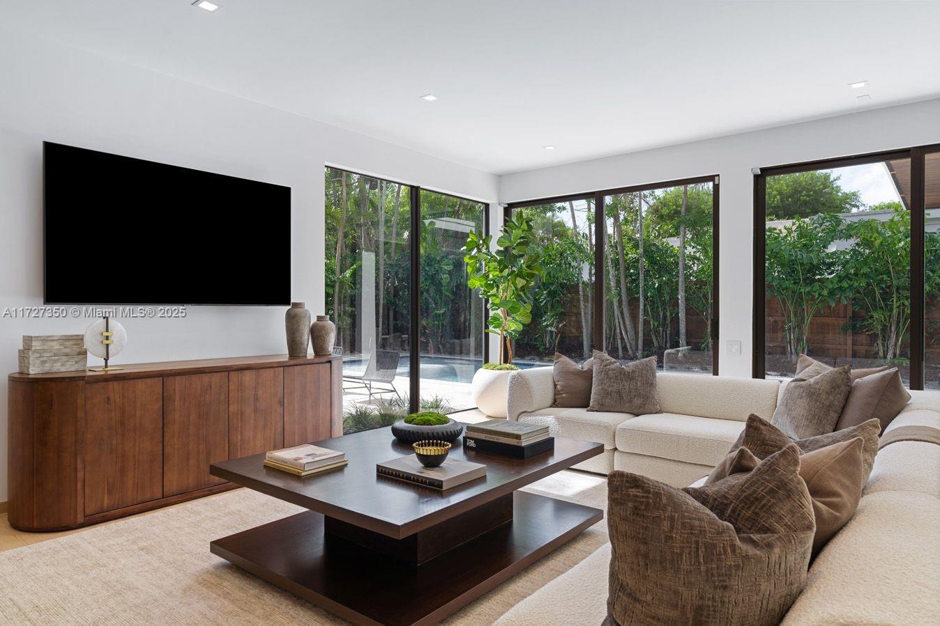 10 Pinta Road Miami, FL 33133 - Photo 22 of 28 a living room with furniture a flat screen tv and a large window
