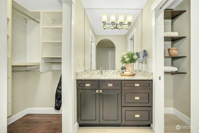 a bathroom with a granite countertop sink a mirror and a shower