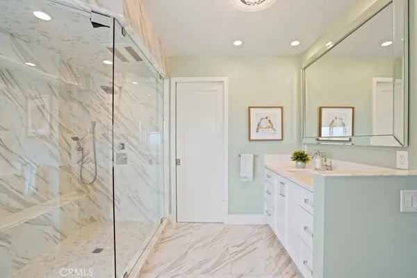 a spacious bathroom with a shower sink and mirror