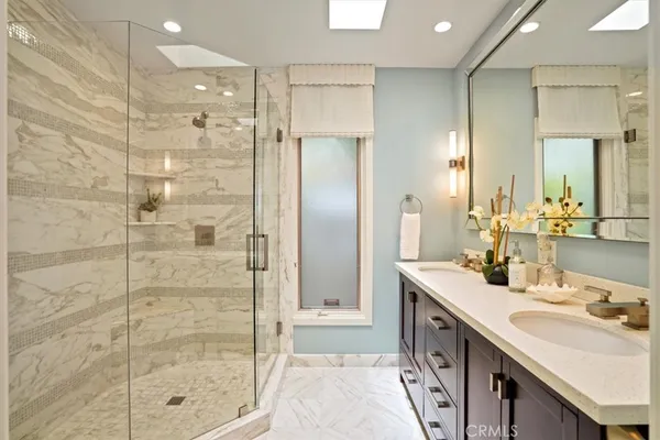 a bathroom with a double vanity sink mirror and shower