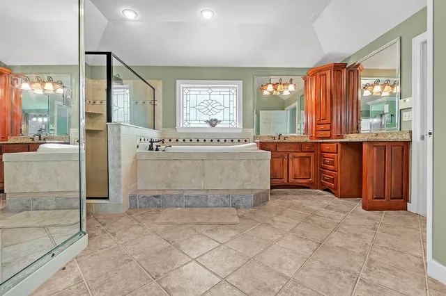 a large en suite bathroom with a tub sink and mirror