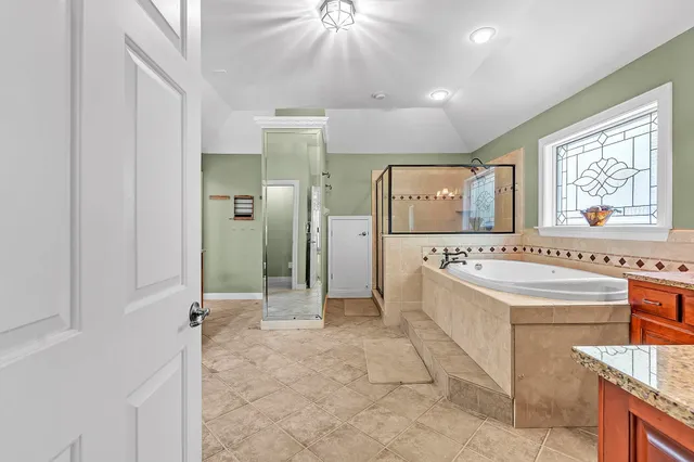 a bathroom with a tub sink and mirror