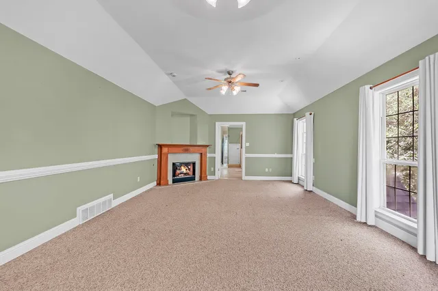 an empty room with windows and ceiling fan
